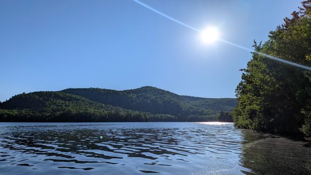Lever de soleil sur le lac Saguay, entouré des collines boisées des Hautes-Laurentides