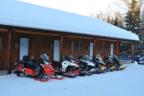 Le motel L'Ours Bleu en hiver, motoneiges stationnées devant les chambres